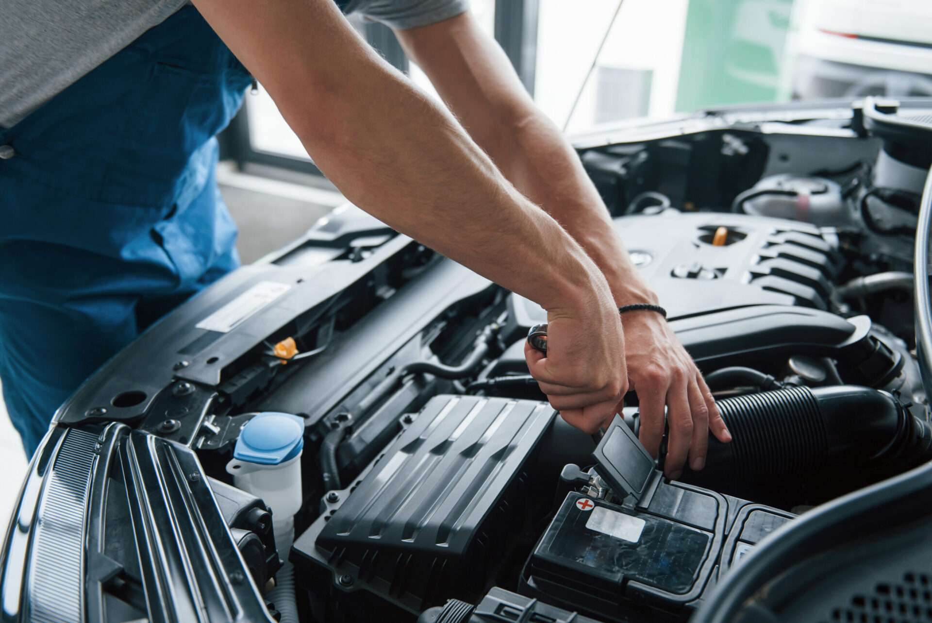 some electronic parts. process of repairing car after accident. man working with engine under the hood